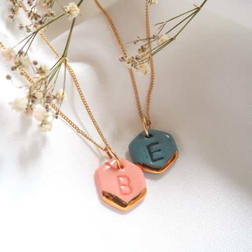 blue and pink hexagons with letters imprinted, gold lustre stripes and attached to gold chains