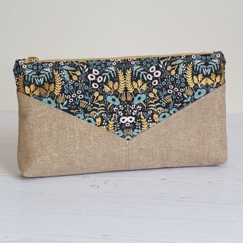 Oblong clutch purse in 2 coordinating metallic fabrics sewn in a V pattern