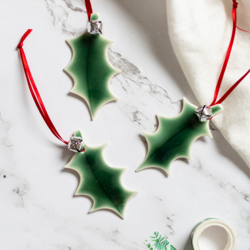 Rachel Carpenter Ceramics, Porcelain Green Holly Leaves with a red ribbon.