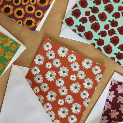 Assortment of Nut Meg Floral Recycled Cards with white envelopes on brown background
